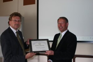 Capt. Rob van Nuland, RNLA (l), Military Intelligence and Security Service/Bureau for Industrial Security, receives a certificate of appreciation for his April presentation from Air Cdre. Gerrit Schoonderbeek, RNLAF (Ret.), chapter vice president. 

